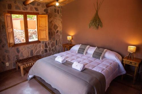 a bedroom with a large bed with towels on it at CasaCalma Hotel Boutique in Tilcara