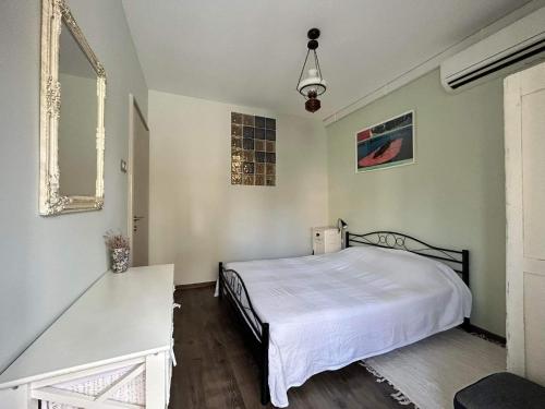 um quarto com uma cama branca e um espelho em The Bookies Apartments em Sófia