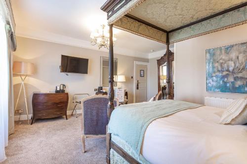 a bedroom with a canopy bed and a dresser at The Swan Hotel, Wells, Somerset in Wells