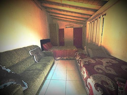 a living room with a couch and two beds at Hostal mburucuyá in Ciudad del Este