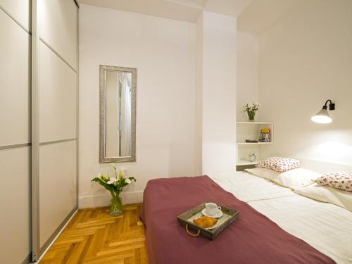 a bedroom with a bed with a tray of food on it at Main Square Apartment in Zagreb