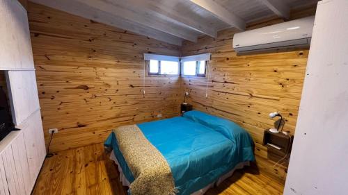 1 dormitorio con paredes de madera y 1 cama en una habitación en El pisito en San Rafael