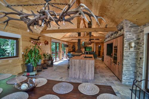 ein großes Wohnzimmer mit einem Tisch und einer Steinmauer in der Unterkunft Chalet : le moulin du sagard in Wisches