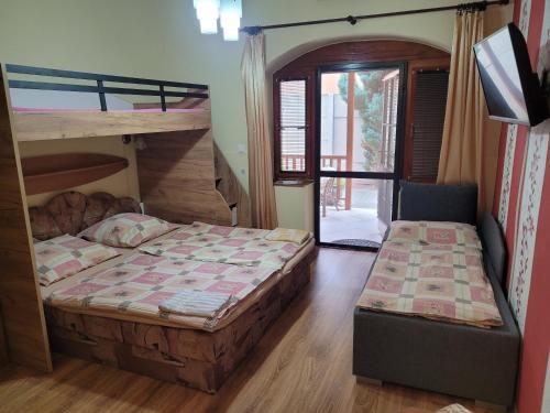 a bedroom with two bunk beds and a chair at Penzión Korzo in Štúrovo