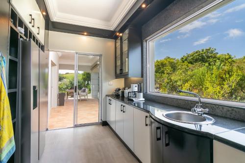 a bathroom with a sink and a large window at BS1 - Pezula Exclusive Elegance in Knysna