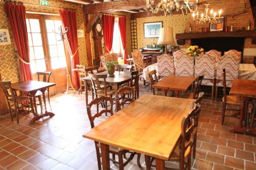 a restaurant with wooden tables and chairs and a fireplace at Golf Hotel in Le Tréport