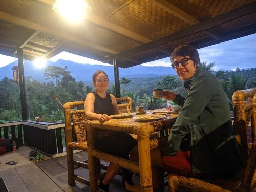 un hombre y una mujer sentados en una mesa en Tetabatu Rice Terrace Homestay, en Tetebatu