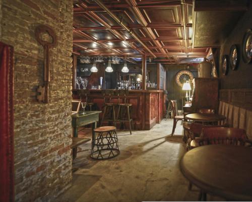 a room with a bar with tables and chairs at Maxwell Mansion Hotel in Lake Geneva