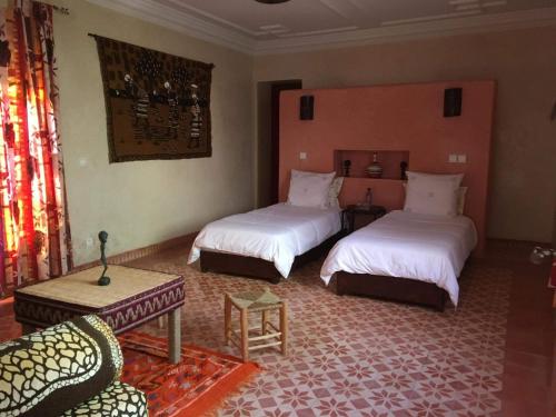 een slaapkamer met 2 bedden en een bank in een kamer bij CHATEAU D'ORIENT in Essaouira