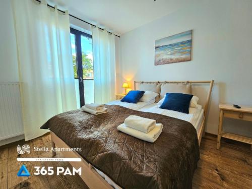 sypialnia z dużym łóżkiem z dwoma ręcznikami w obiekcie Villa Solny Apartament 7 - 365PAM w mieście Ustronie Morskie