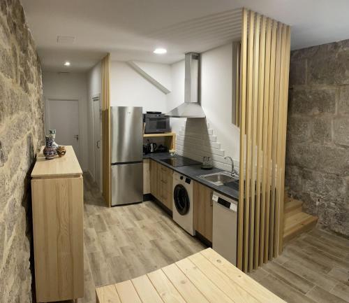 uma cozinha com um frigorífico de aço inoxidável e um lavatório em Casa Arco em Pontevedra
