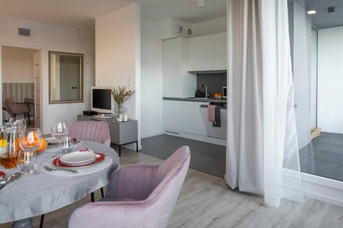 a dining room with a table and chairs and a kitchen at Platinum 1 in Gdynia