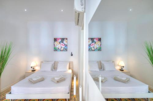 2 camas en una habitación con paredes blancas en Charming 2 bedroom townhouse, internal yard JDES1-1, en Il-Gżira