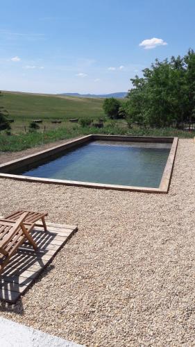 - une piscine avec un banc et une table de pique-nique dans l'établissement Chambre à la ferme au milieu des lavandes, à Valensole
