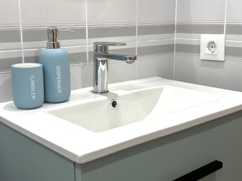a white bathroom sink with a blue bottle on it at Face a la Mer - vue epique, climatisation, wifi, draps inclus in Empuriabrava