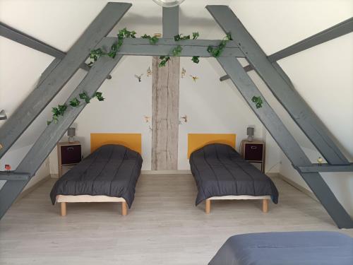 two beds in a room with a ceiling at Gite la Ressource O' Naturel in Bonningues-lès-Ardres