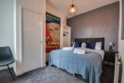 ein Schlafzimmer mit einem Bett und einem Poster eines Mannes in der Unterkunft Antonio str Liverpool 8 beds in Liverpool