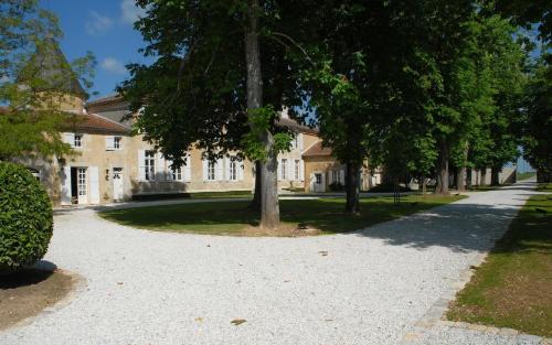a large building with trees in front of it at Le Logis du Péré in Saint-Coutant-le-Grand