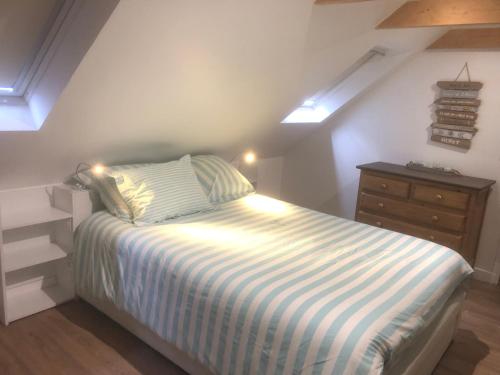 a small bedroom with a bed and a dresser at Gite équestre du Dourdu in Lopérec