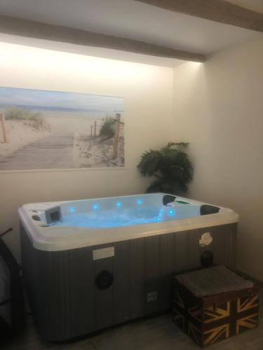 a large bath tub in a room with a painting at Gite équestre du Dourdu in Lopérec
