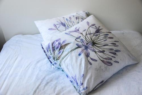 - un oreiller avec un motif floral sur le lit dans l'établissement "Urbaine Jardin" Charmant studio idéalement situé "Les Péri-Urbaines", à Riedisheim