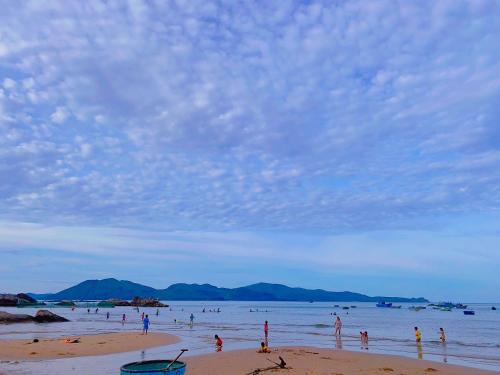 a group of people standing in the water on a beach at phòng mùa thu in Tuy Hoa