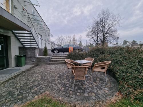 a table and chairs on a patio outside of a building at Biłgoraj Aparthotel in Biłgoraj