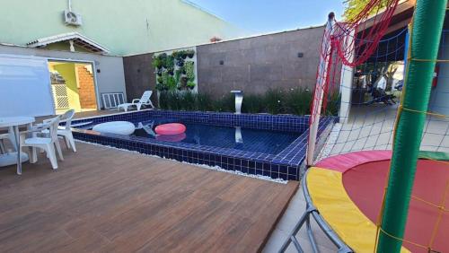 a backyard with a pool with a table and chairs at Pousada Vila Real PG in Praia Grande