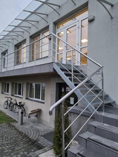a house with a metal railing on the stairs at Biłgoraj Aparthotel in Biłgoraj