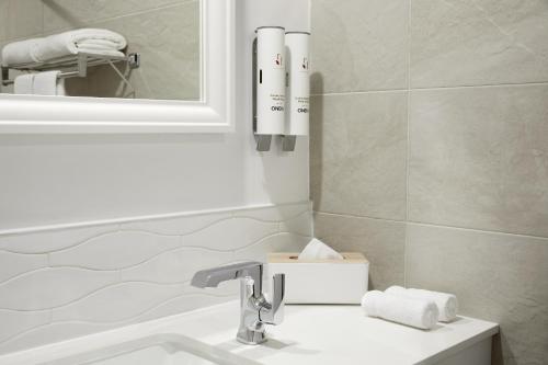 a bathroom with a sink and a mirror at Hotel Ruby Foo's in Montréal