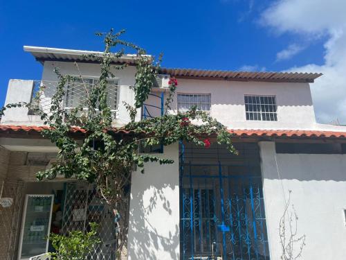 une maison blanche avec une porte fleurie dans l'établissement Casa Siulan, à Porto de Galinhas