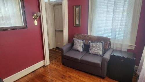a living room with a couch and a red wall at Greystone Manor Bed & Breakfast in Bird in Hand