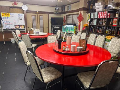 a dining room with red tables and chairs at 民宿ふじ苑 