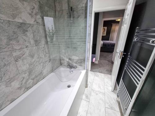 a bathroom with a bath tub with a cat sitting in it at 3 BR Home Close to MCR City Centre in Manchester
