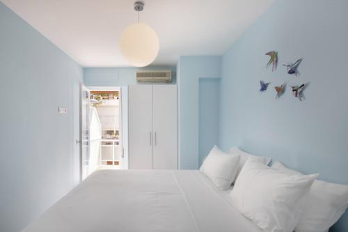 ein weißes Bett mit weißen Kissen in einem Zimmer in der Unterkunft Hatzikosta11 in Athen