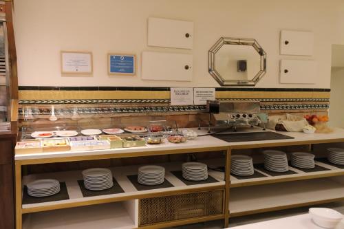 a display case in a bakery with plates and food at YIT Casablanca in Granada