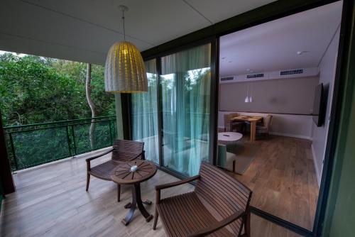 Habitación con balcón con mesa y sillas. en Iguazu Jungle Lodge en Puerto Iguazú