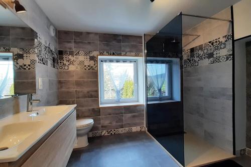 a bathroom with a toilet and a sink and a shower at Villa Magnolia 8 personnes in Coubon