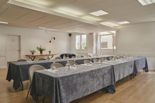 a row of tables in a room with blue table cloth at Tres Torres Atiram Hotel in Barcelona