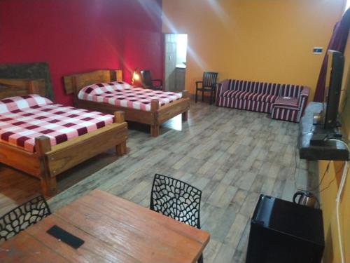 een kamer met 2 bedden en een tafel en stoelen bij Quinta Don Adolfo in Puerto Iguazú