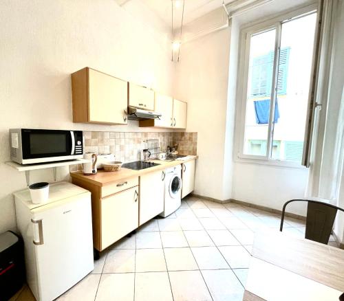 a small kitchen with a sink and a microwave at Colonna Istria in Nice