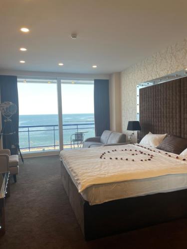 a bedroom with a large bed and a large window at Apartaments Sea in Odesa