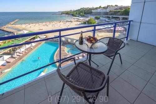 a balcony with a table and chairs and a swimming pool at Apartaments Sea in Odesa