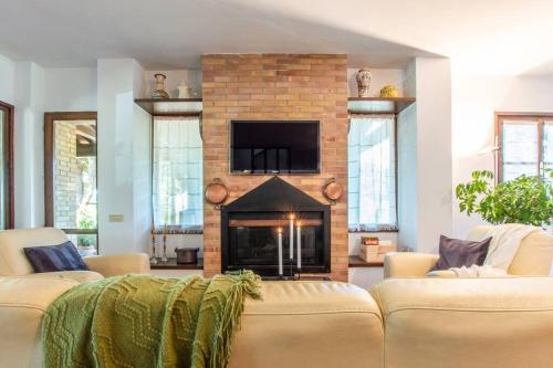 a living room with two couches and a fireplace at Sangiovese - Villetta nella campagna toscana in Abbadia di Montepulciano