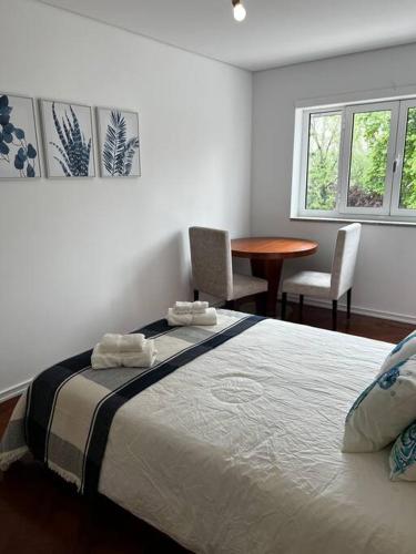 a bedroom with a bed and a table and chairs at Casa da Praça 2 in São João da Madeira