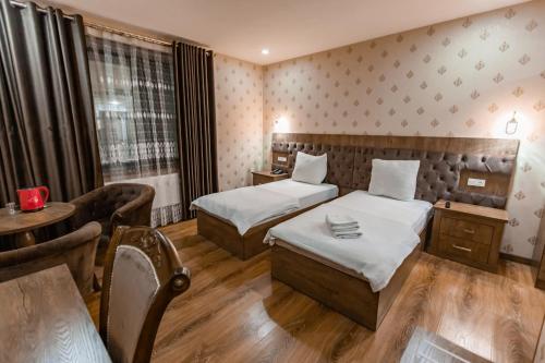 a hotel room with two beds and a table at OydinPlaza Hotel in Namangan