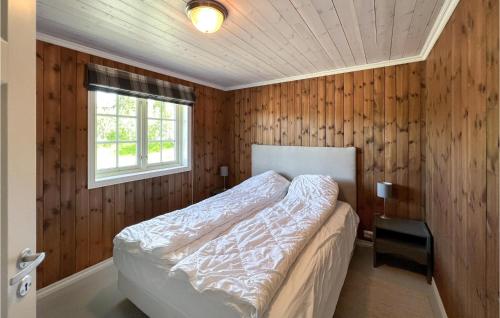 Amazing Home In Nord-torpa With Kitchen في Nord Torpa: غرفة نوم بجدران خشبية وسرير مع نافذة