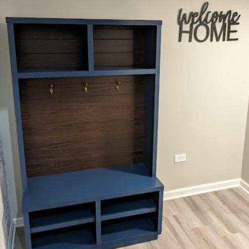 a blue book shelf in a room with a welcome home sign at Fully Furnished Extended Stay Work or Insurance in Chicago in Chicago