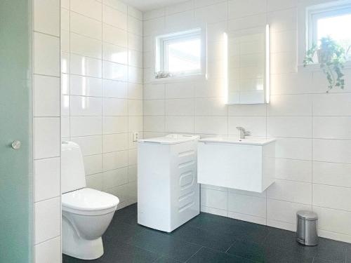 a white bathroom with a toilet and a sink at 4 person holiday home in BORGHOLM-By Traum in Borgholm