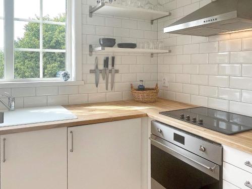 a kitchen with white cabinets and a stove top oven at 4 person holiday home in BORGHOLM-By Traum in Borgholm